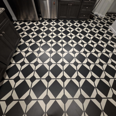 A black and white geometric tile floor with a repeating pattern of diamonds and squares.